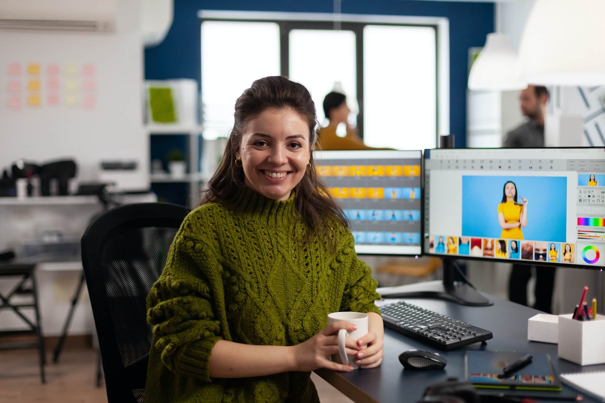 WOMAN RETOUCHER LOOKING AT CAMERA SMILING WORKING IN CREATIVE MEDIA AGENCY 1
